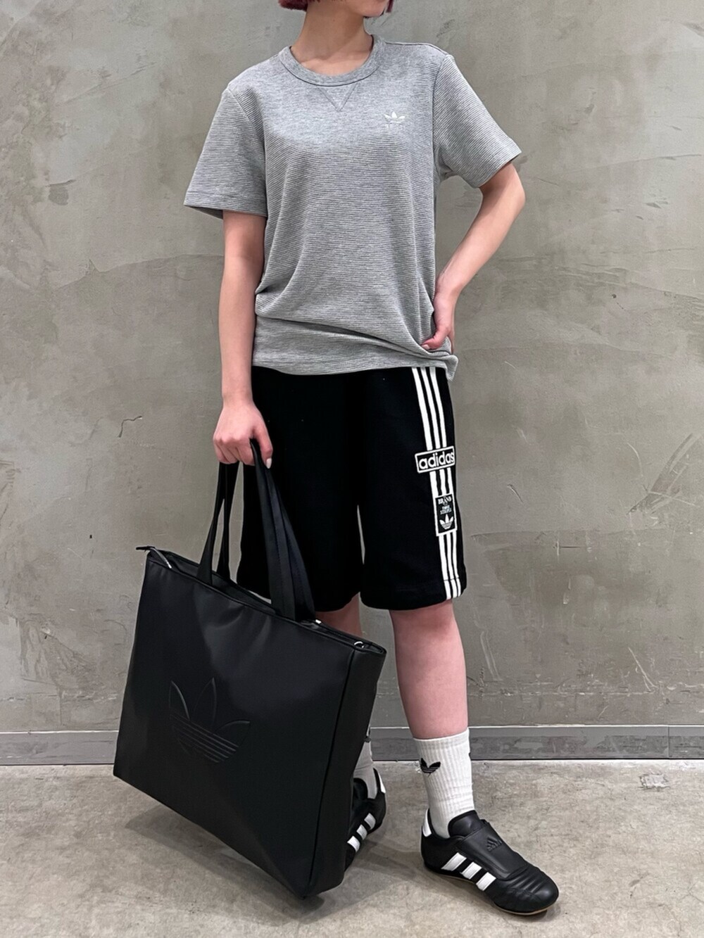 ブラック系のシューズ、ブラック系のデニムパンツ、グレー系のトップスを着用したレディースの春コーディネートの2枚目の写真