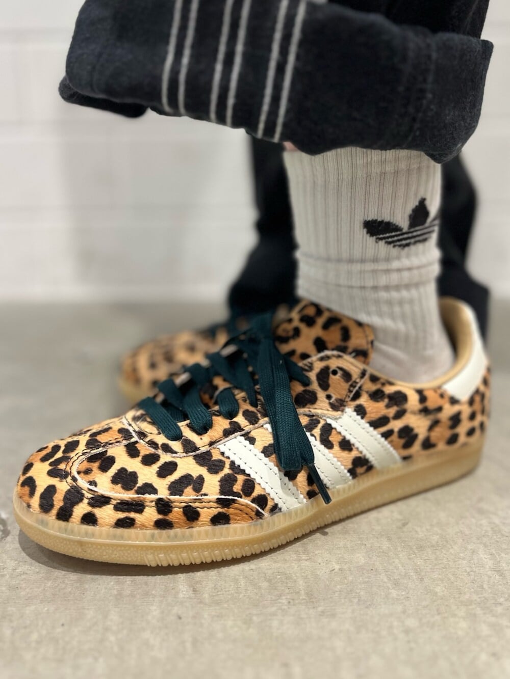 ブラック系のショルダーバッグ、ベージュ系のスニーカー、ブラック系のジャージを着用したレディースの冬コーディネートの6枚目の写真