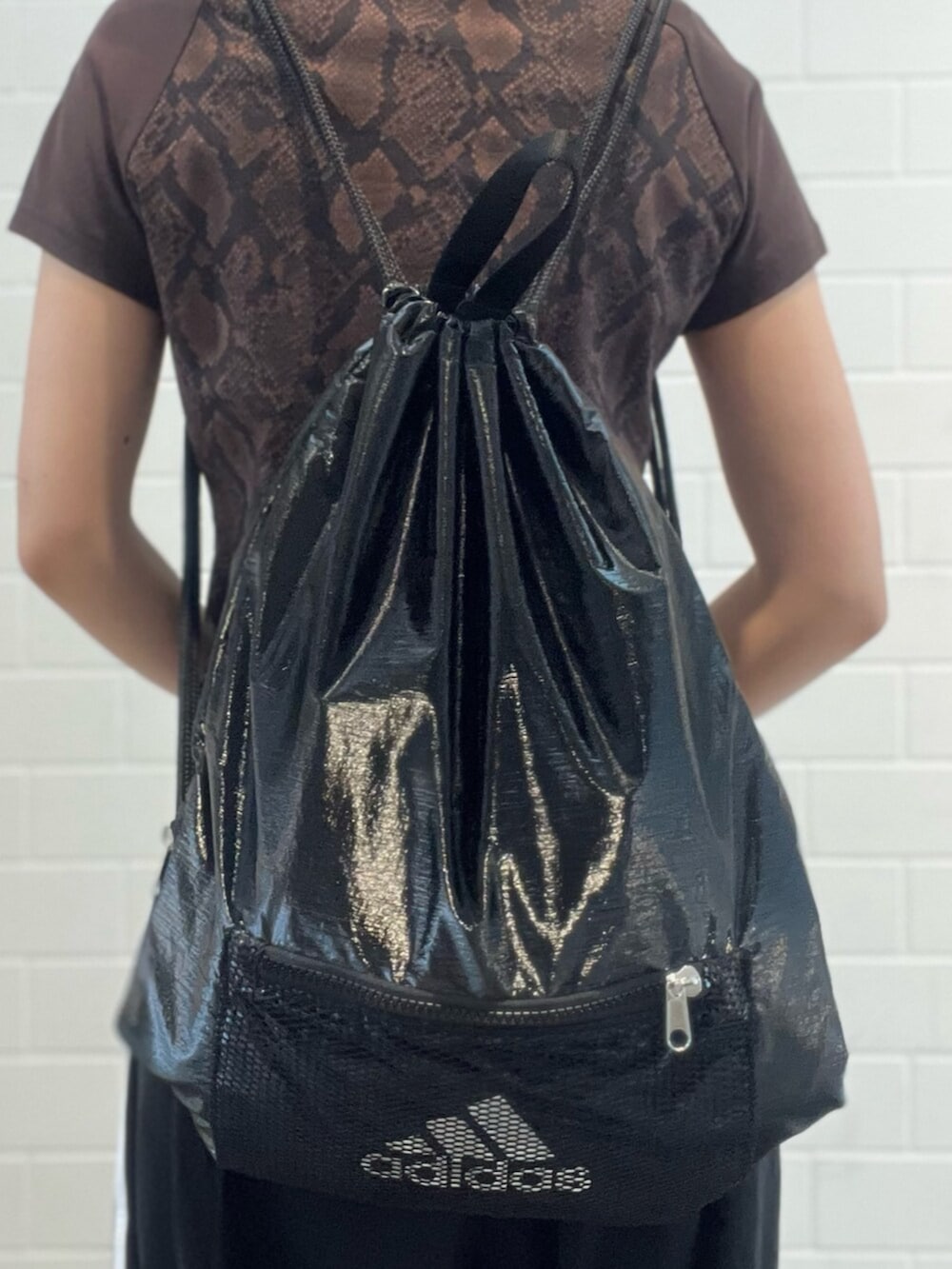 ブラック系のスニーカー、ブラック系のエコバッグ/サブバッグ、ブラウン系のTシャツ/カットソーを着用したレディースの夏コーディネートの4枚目の写真