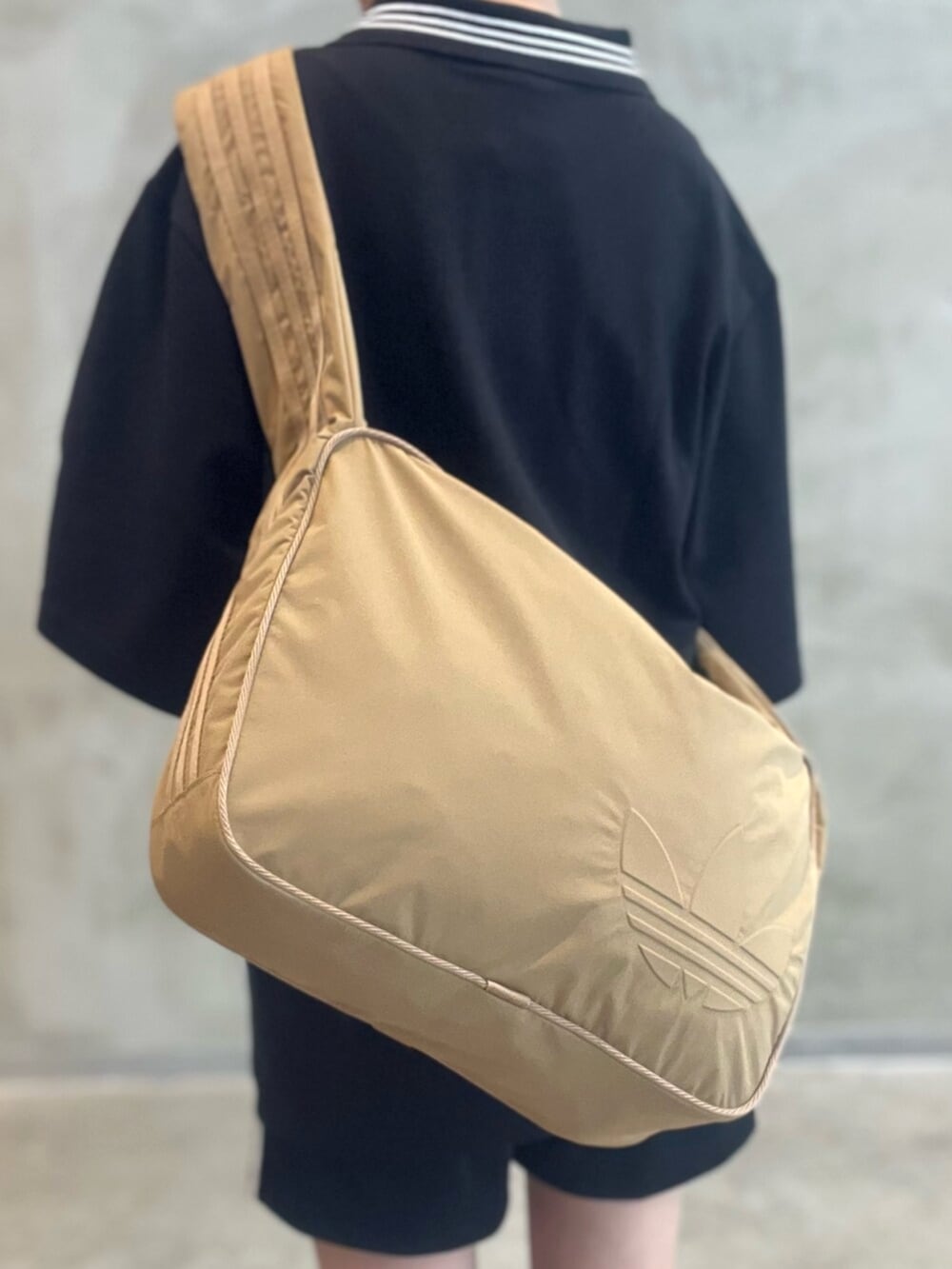 ブラウン系のショルダーバッグ、ブラック系のその他パンツ、ブラック系のポロシャツを着用したレディースの秋コーディネートの5枚目の写真