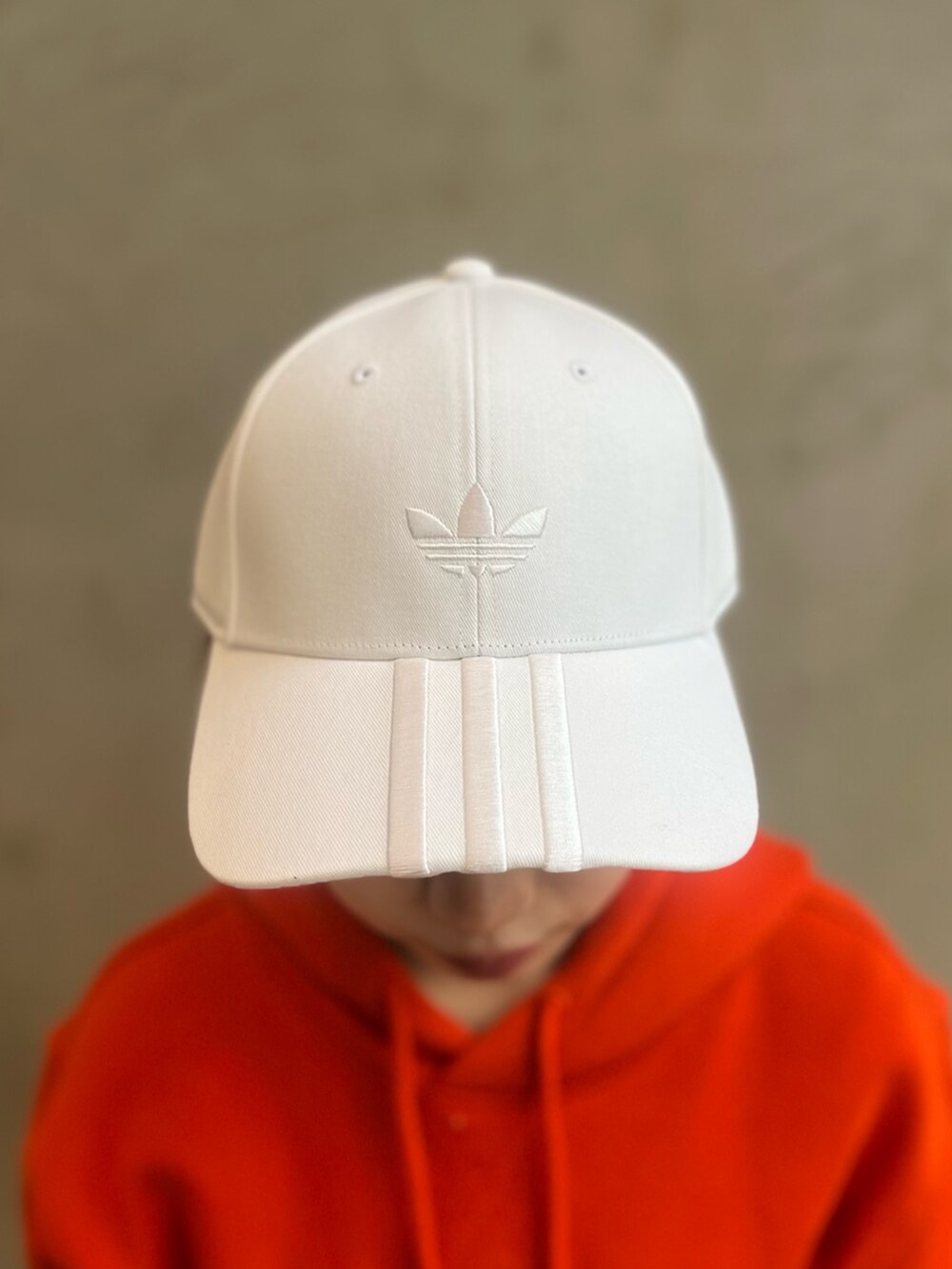 ブラウン系のカーゴパンツ、ホワイト系のシューズ、オレンジ系のパーカーを着用したレディースの冬コーディネートの4枚目の写真