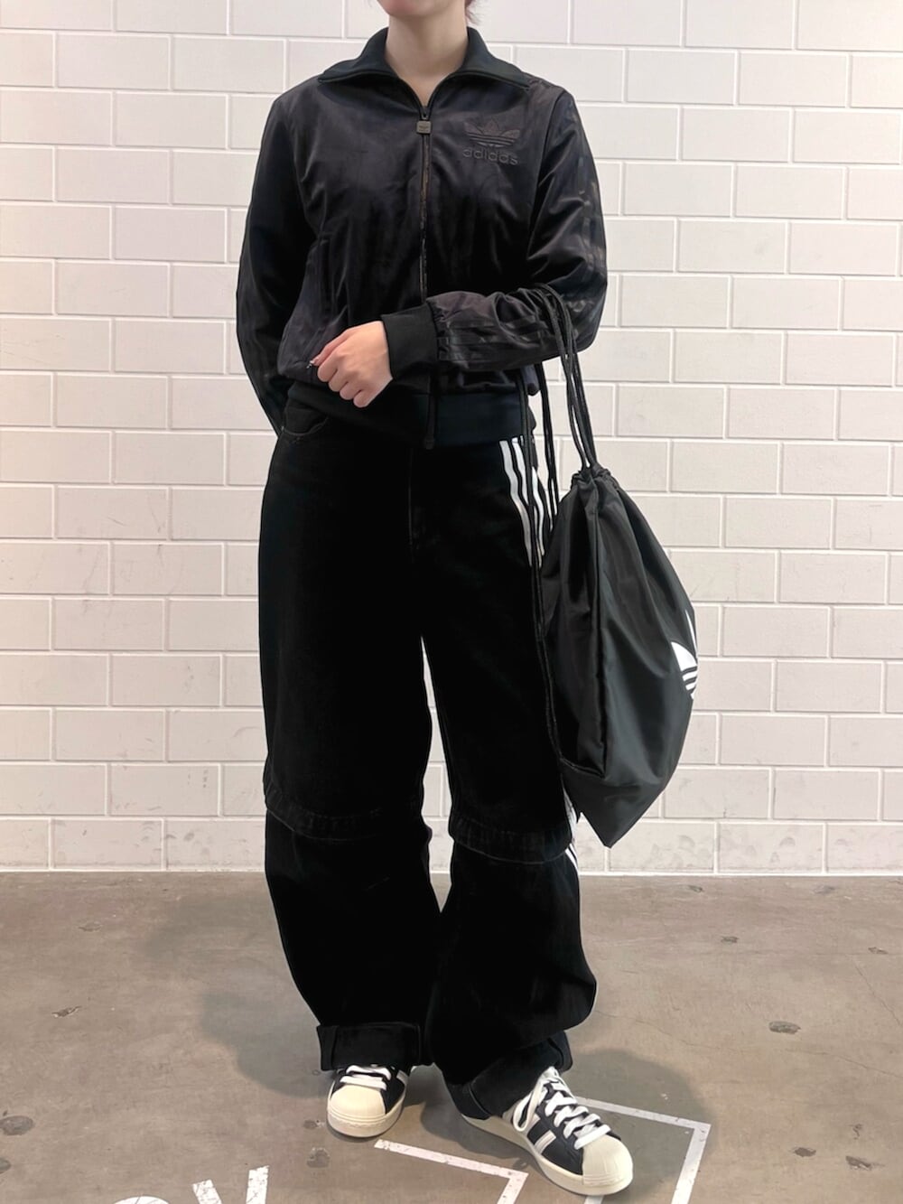 ブラック系のエコバッグ/サブバッグ、ブラック系のデニムパンツ、ブラック系のシューズを着用したレディースの冬コーディネートの2枚目の写真