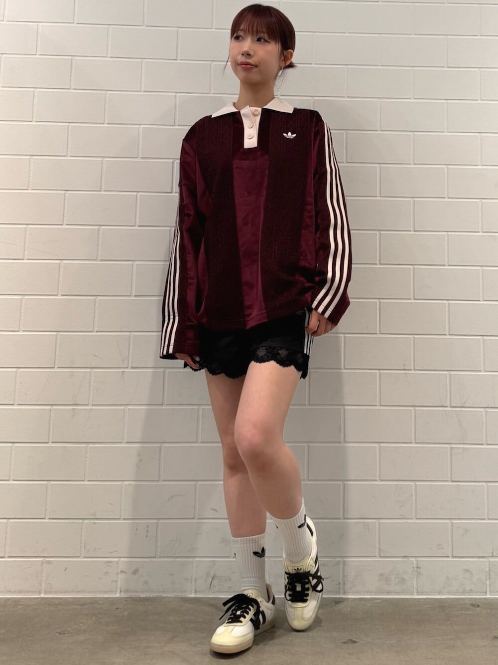 ブラック系のその他パンツ、ホワイト系のスニーカー、レッド系のトップスを着用したレディースの秋コーディネートの3枚目の写真