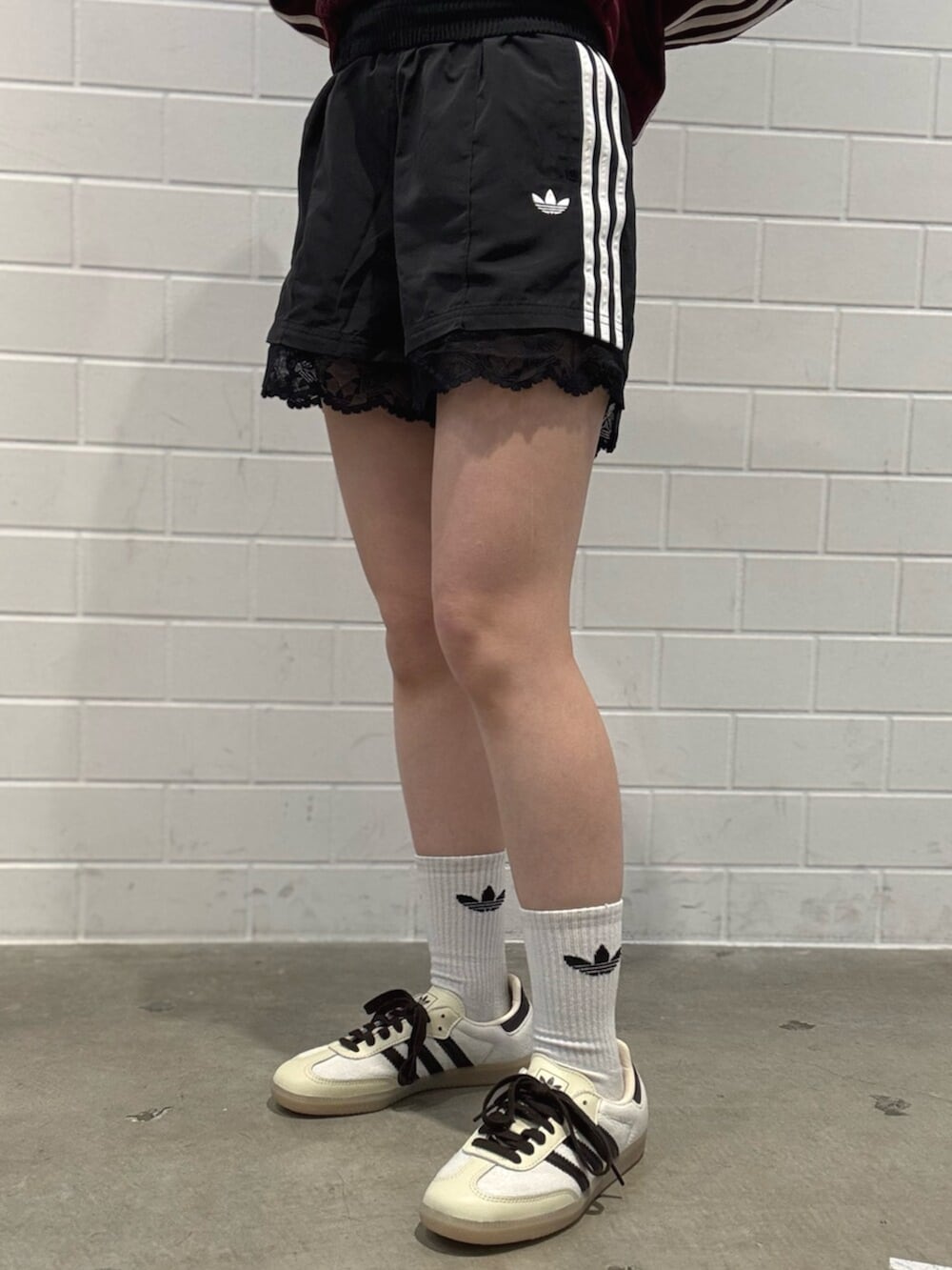 ブラック系のその他パンツ、ホワイト系のスニーカー、レッド系のトップスを着用したレディースの秋コーディネートの5枚目の写真