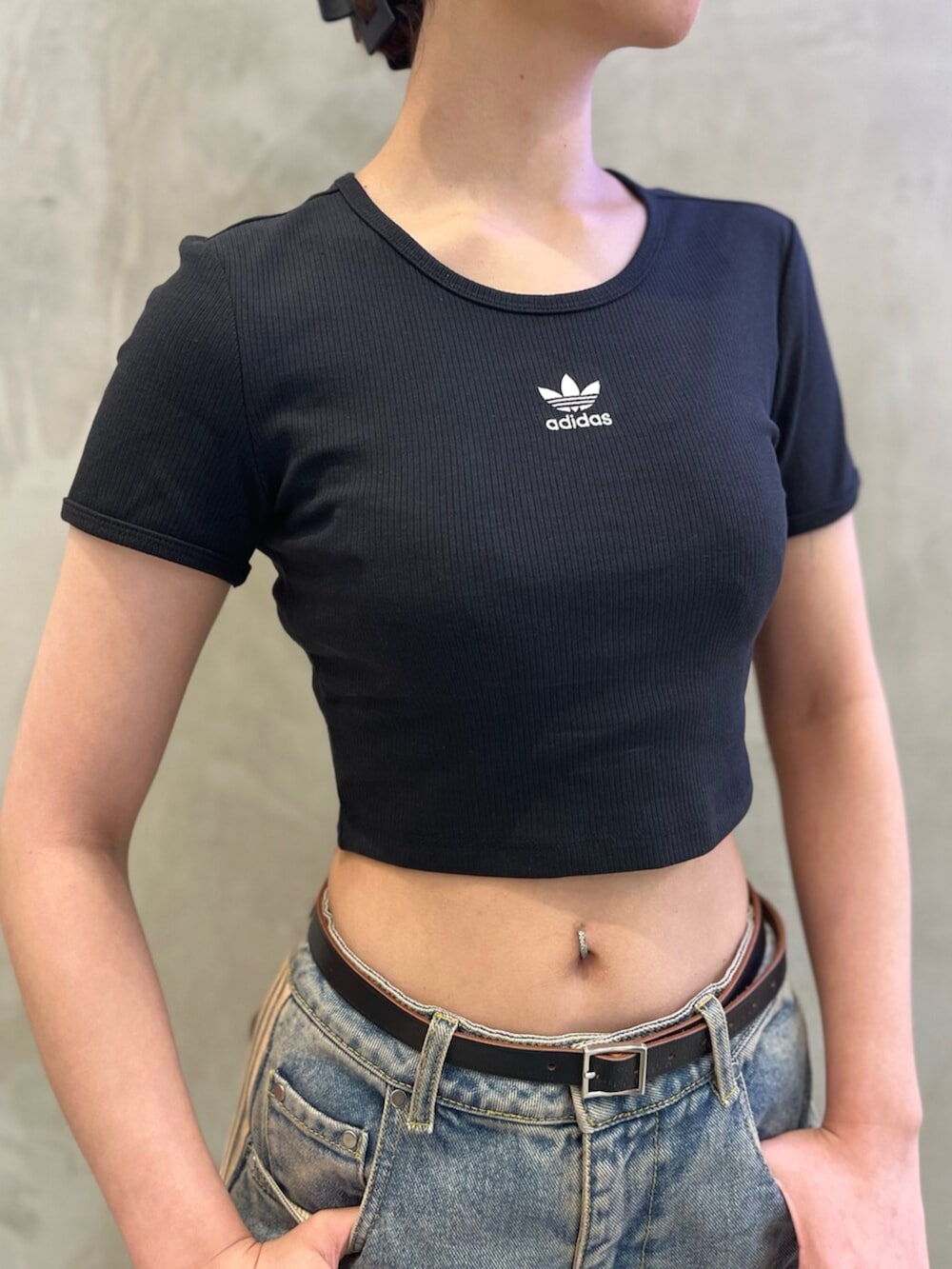 ブラック系のTシャツ/カットソー、ベージュ系のショルダーバッグ、ブルー系のデニムパンツを着用したレディースの秋コーディネートの3枚目の写真