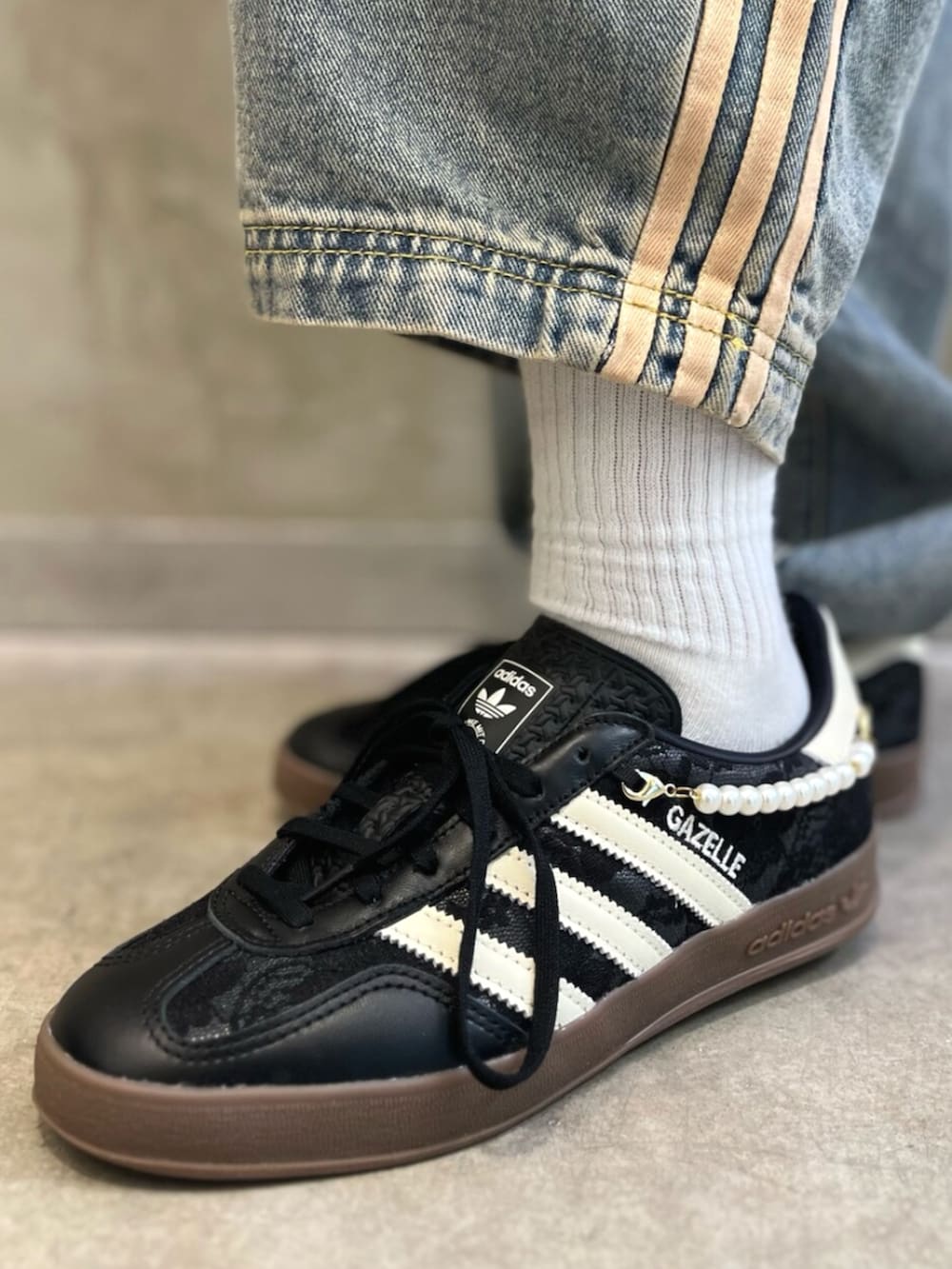 ブラック系のTシャツ/カットソー、ベージュ系のショルダーバッグ、ブルー系のデニムパンツを着用したレディースの秋コーディネートの6枚目の写真