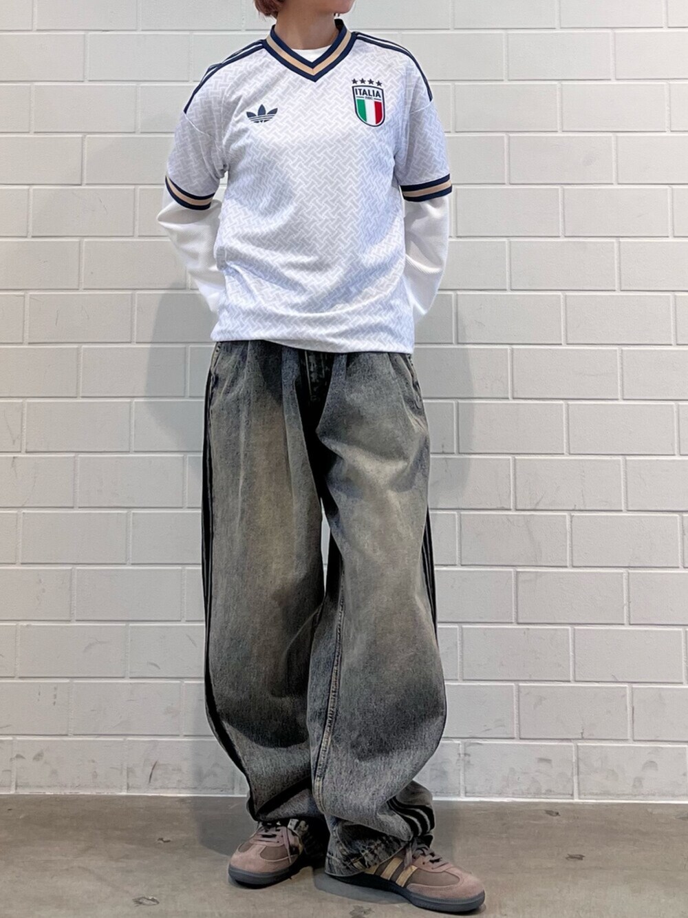 ブラウン系のスニーカー、ブルー系のTシャツ/カットソー、ブラウン系のデニムパンツを着用したレディースの春コーディネートの2枚目の写真