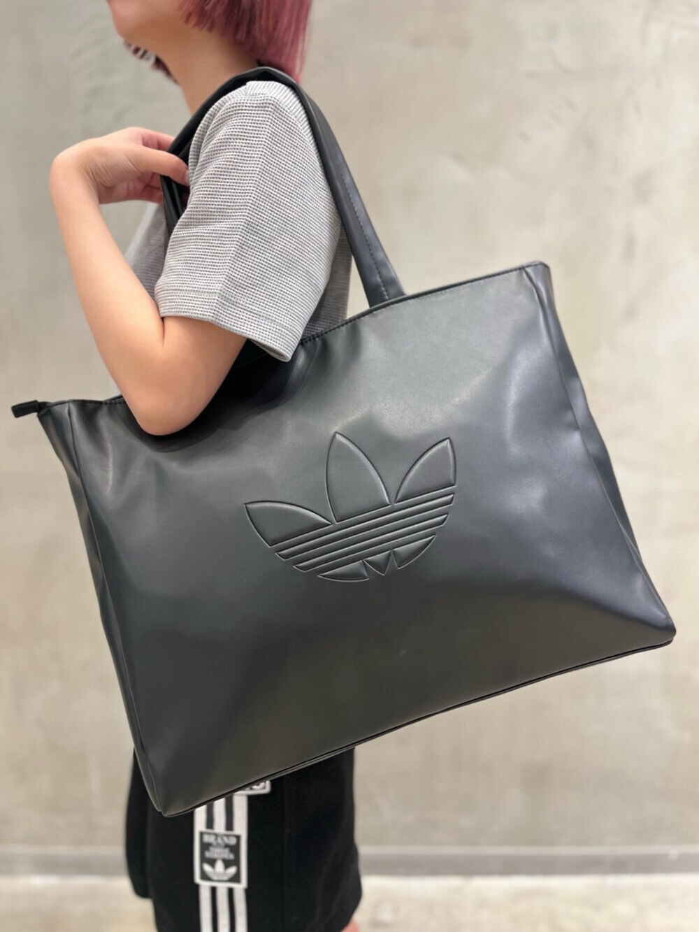 ブラック系のシューズ、ブラック系のデニムパンツ、グレー系のトップスを着用したレディースの春コーディネートの5枚目の写真