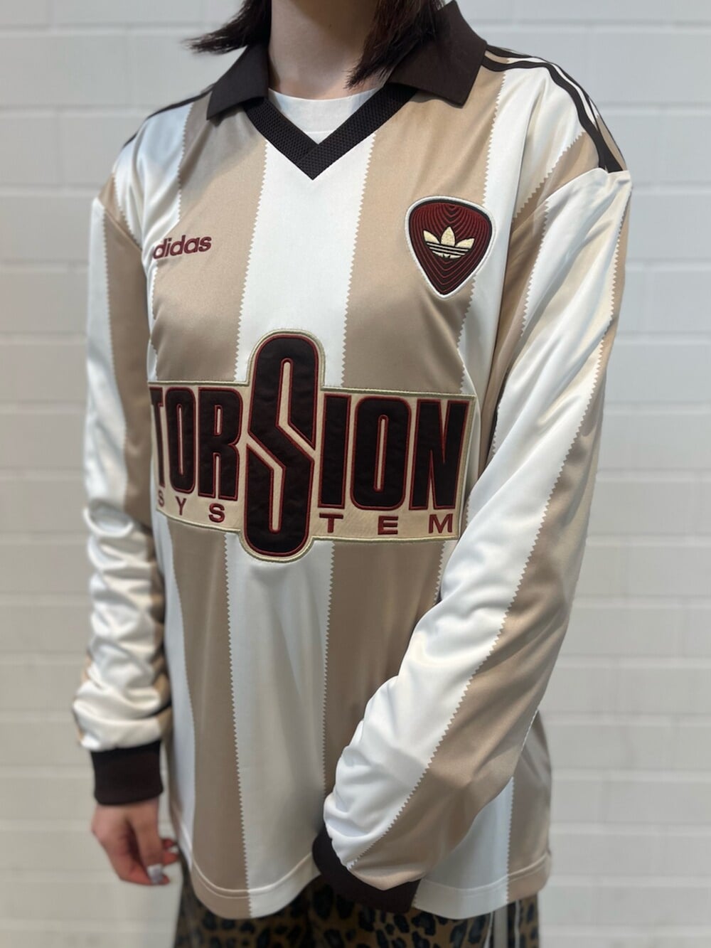 ブラック系のショルダーバッグ、ブラック系のスニーカー、ホワイト系のトップスを着用したレディースの冬コーディネートの4枚目の写真