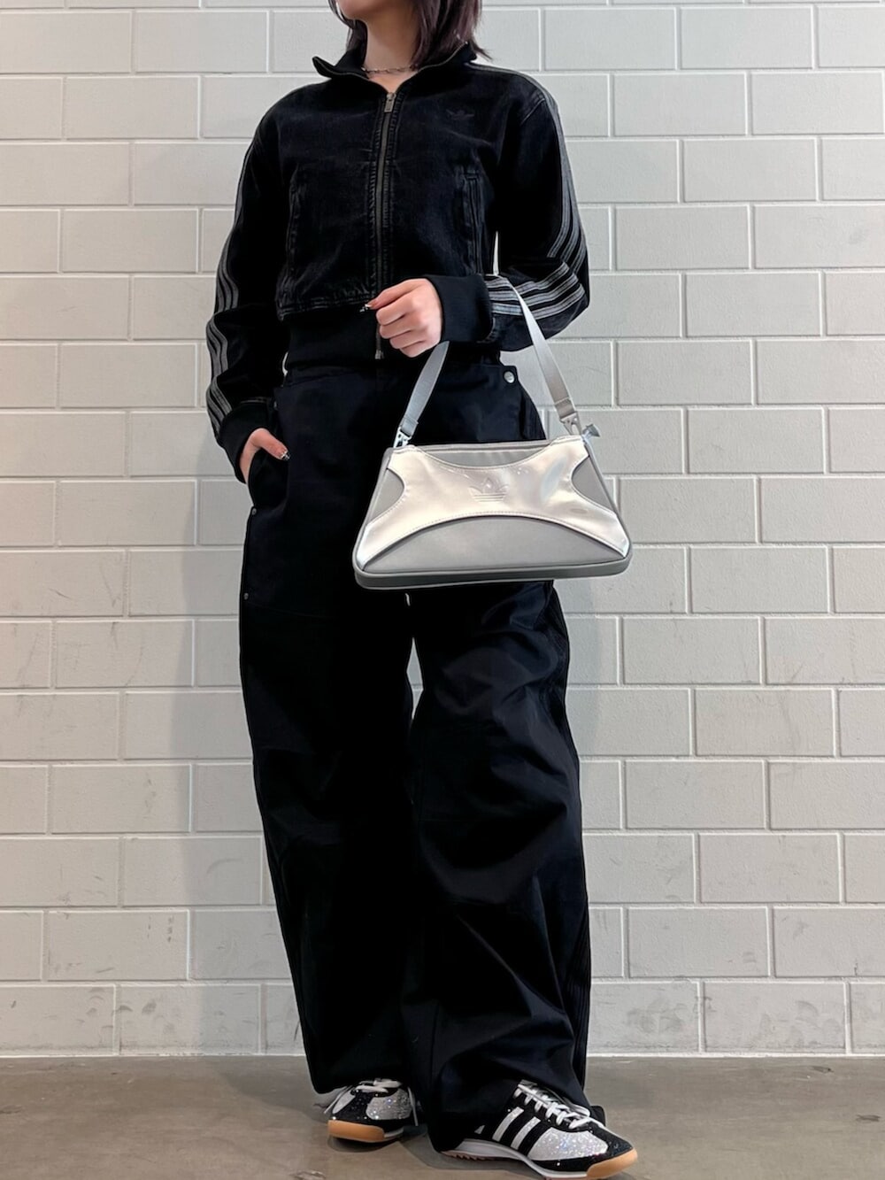 シルバー系のショルダーバッグ、ブラック系のデニムジャケット、ブラック系のその他パンツを着用したレディースの冬コーディネートの2枚目の写真