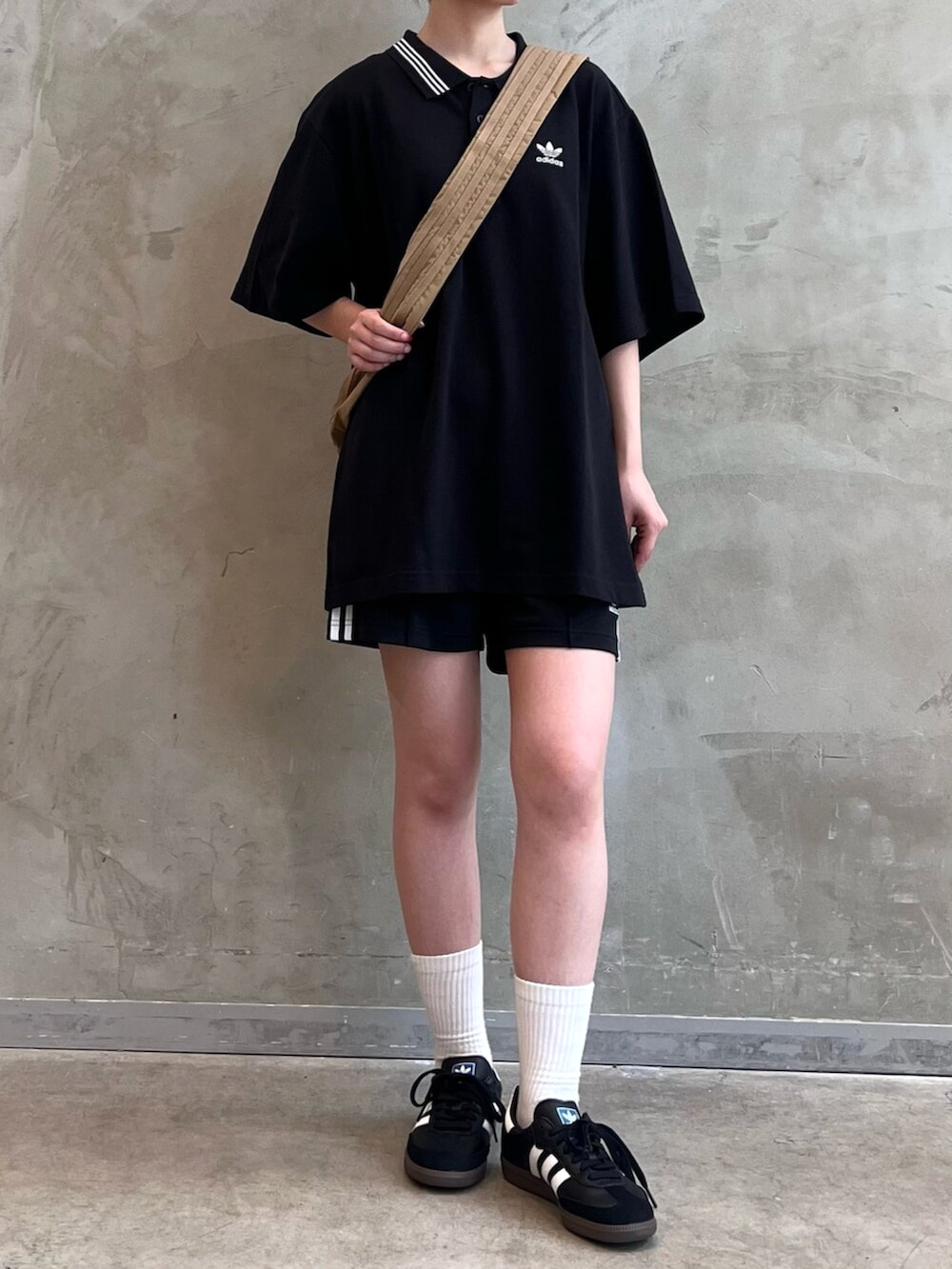 ブラウン系のショルダーバッグ、ブラック系のその他パンツ、ブラック系のポロシャツを着用したレディースの秋コーディネートの2枚目の写真