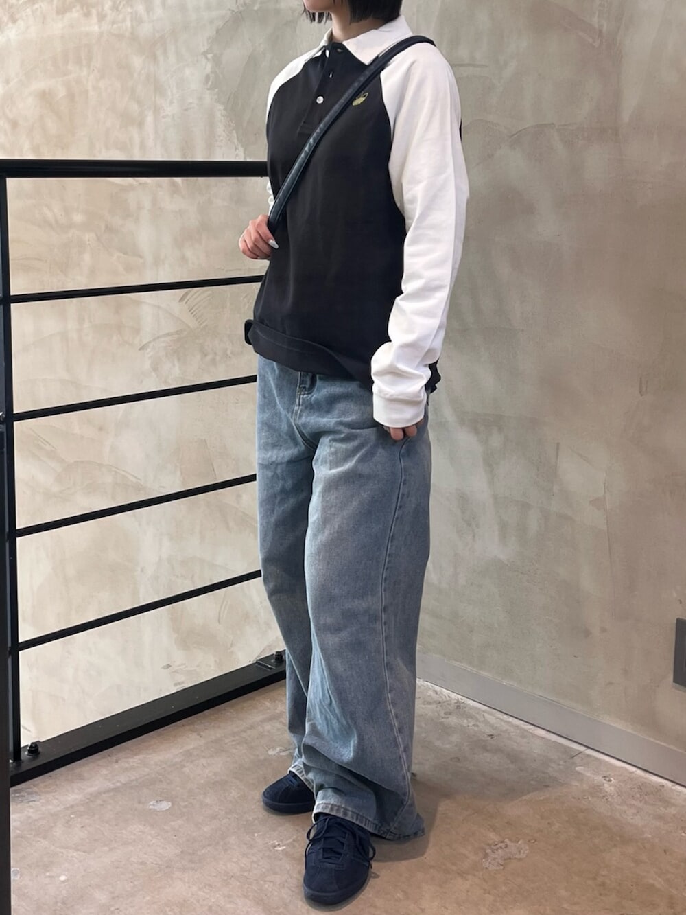 ブルー系のシューズ、ブルー系のショルダーバッグ、ブラック系のポロシャツを着用したレディースの冬コーディネートの2枚目の写真