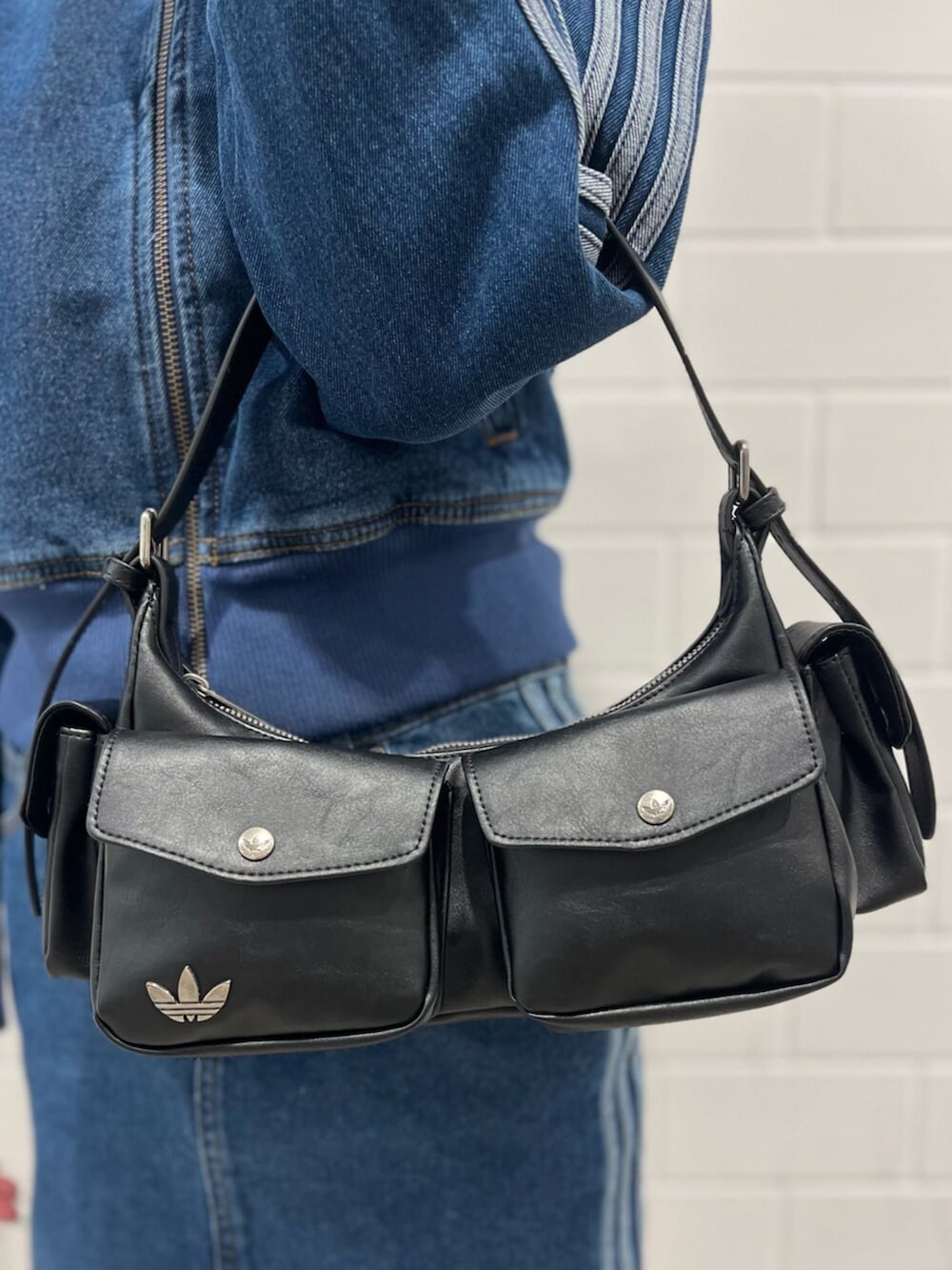 ブラック系のショルダーバッグ、ピンク系のシューズ、ブルー系のジャージを着用したレディースの冬コーディネートの4枚目の写真