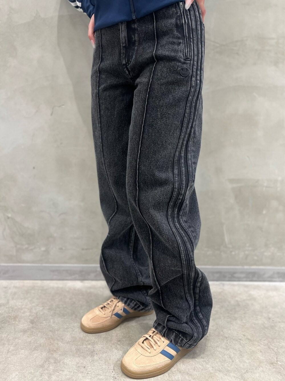 ブラック系のデニムパンツ、ベージュ系のスニーカー、ブルー系のジャージを着用したレディースの夏コーディネートの5枚目の写真