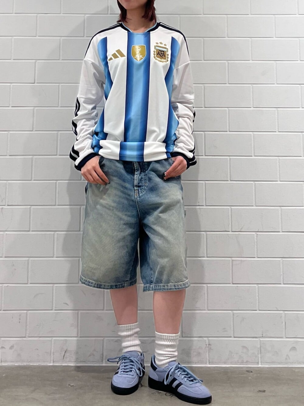 ブルー系のスニーカー、ホワイト系のトップスを着用したレディースの秋コーディネートの2枚目の写真