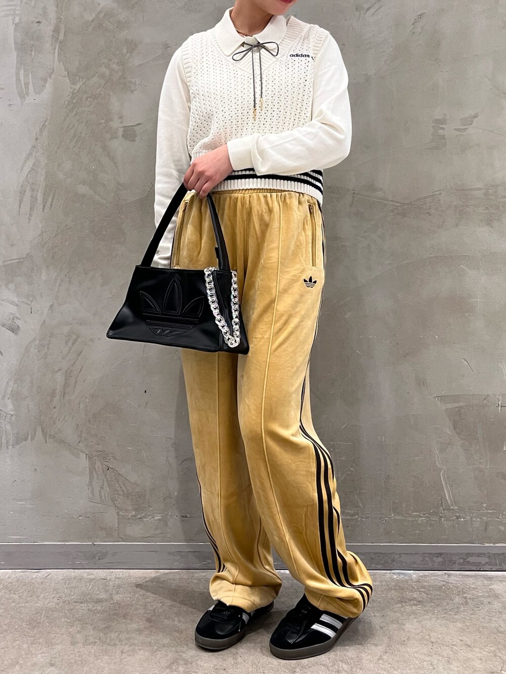 ホワイト系のベスト、ベージュ系のその他パンツ、ブラック系のシューズを着用したレディースの秋コーディネートの2枚目の写真