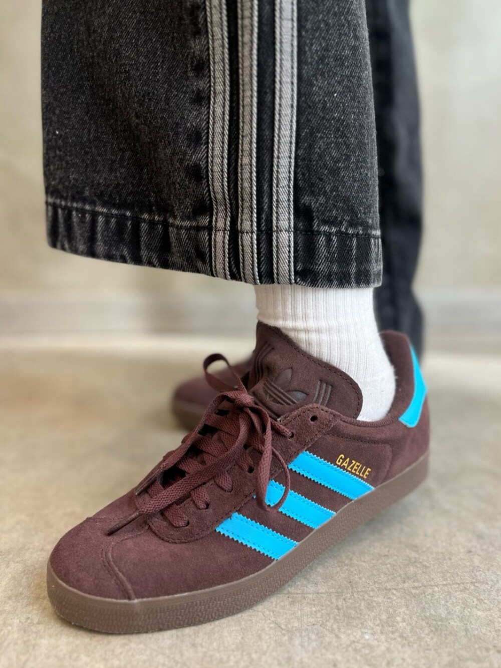 ブラック系のデニムパンツ、ブラウン系のスニーカー、ブラウン系のトップスを着用したレディースの冬コーディネートの6枚目の写真