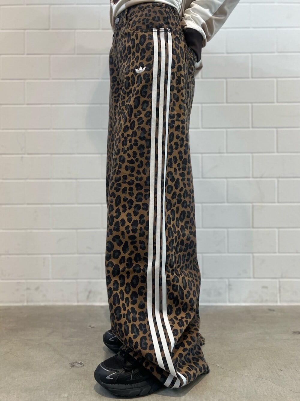 ブラック系のショルダーバッグ、ブラック系のスニーカー、ホワイト系のトップスを着用したレディースの冬コーディネートの7枚目の写真