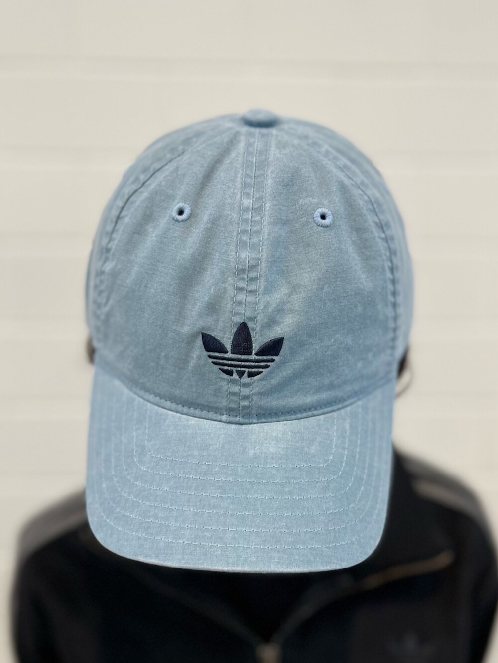 ブラック系のデニムジャケット、ホワイト系のスニーカー、ブルー系のアクセサリーを着用したレディースの春コーディネートの4枚目の写真