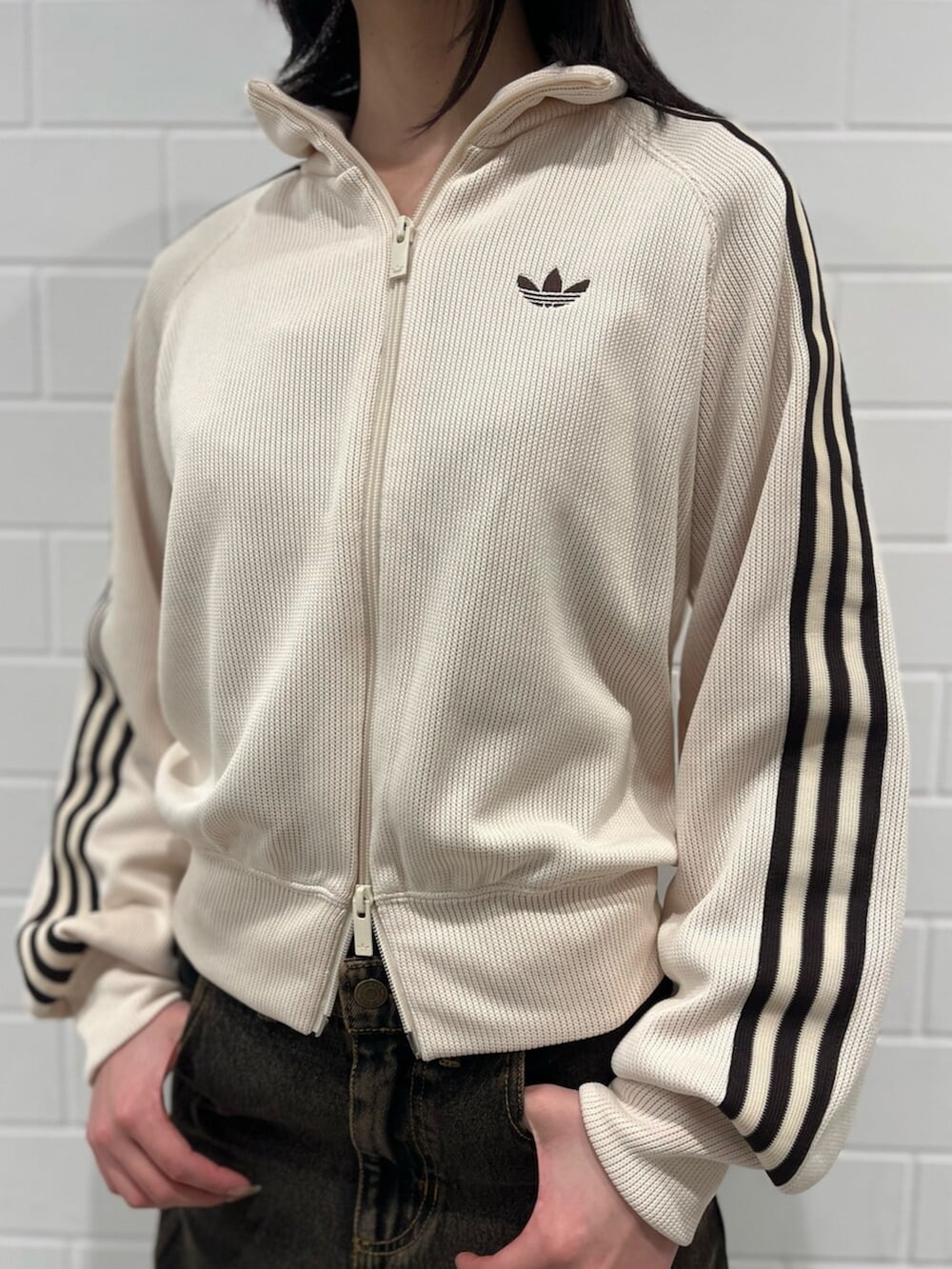 ブラック系のショルダーバッグ、ホワイト系のジャージ、ブラウン系のパンツを着用したレディースの冬コーディネートの3枚目の写真