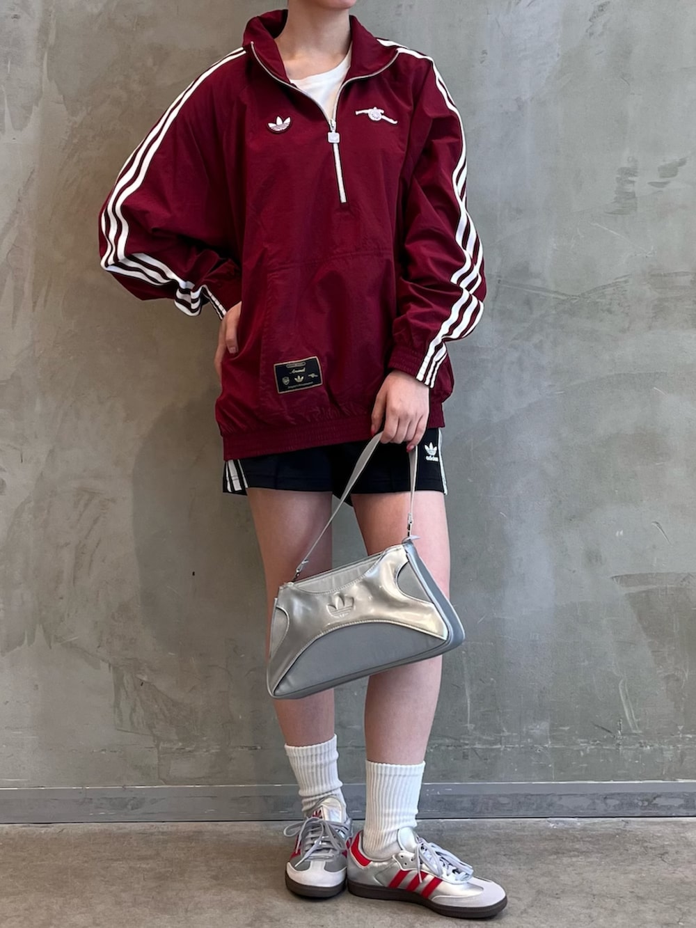 シルバー系のシューズ、シルバー系のショルダーバッグ、レッド系のトップスを着用したレディースの夏コーディネートの2枚目の写真