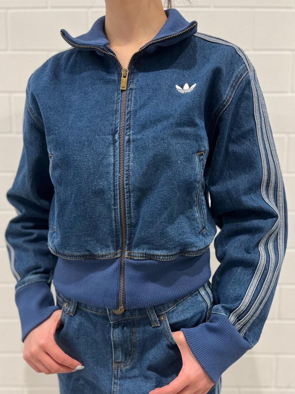 ブラック系のショルダーバッグ、ピンク系のシューズ、ブルー系のジャージを着用したレディースの冬コーディネートの3枚目の写真