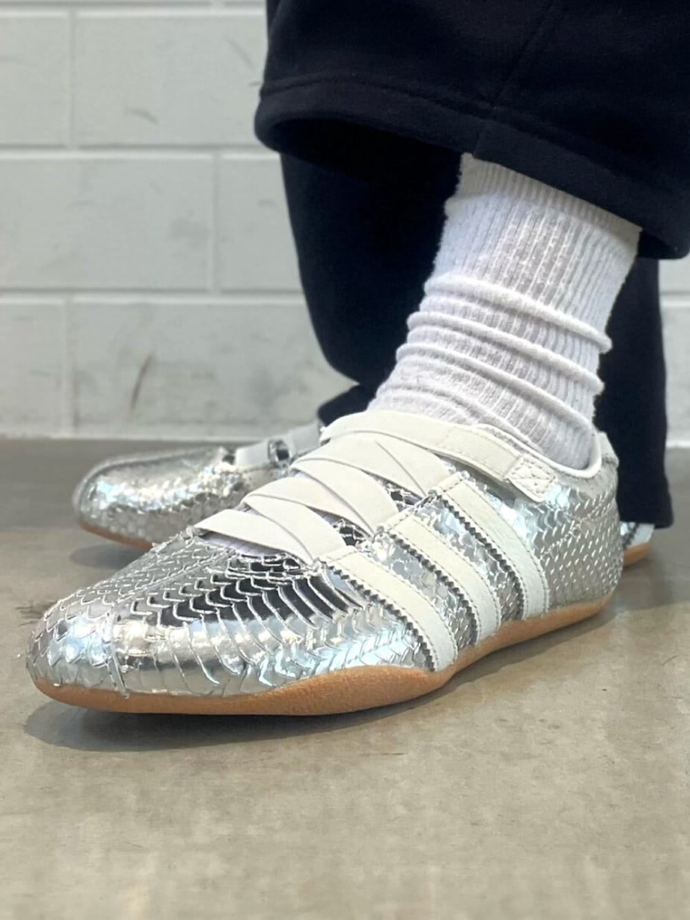 ブラック系のショルダーバッグ、シルバー系のスニーカー、ブルー系のナイロンジャケットを着用したレディースの春コーディネートの6枚目の写真