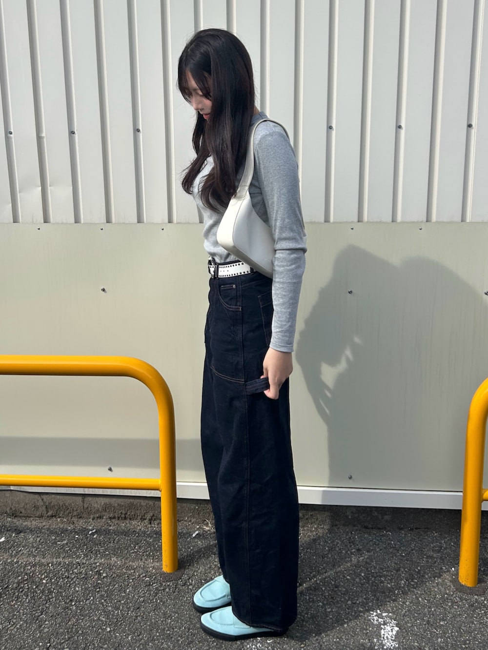 ブルー系のスニーカー、ホワイト系のバッグ、グレー系のトップスを着用したレディースの秋コーディネートの2枚目の写真