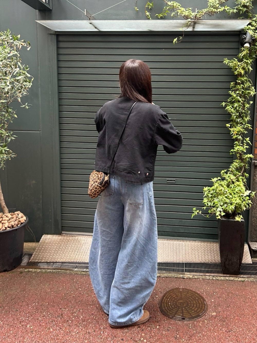 ブラック系のその他アウター、レッド系のその他トップス、ブラウン系のスニーカーを着用したレディースの秋コーディネートの2枚目の写真