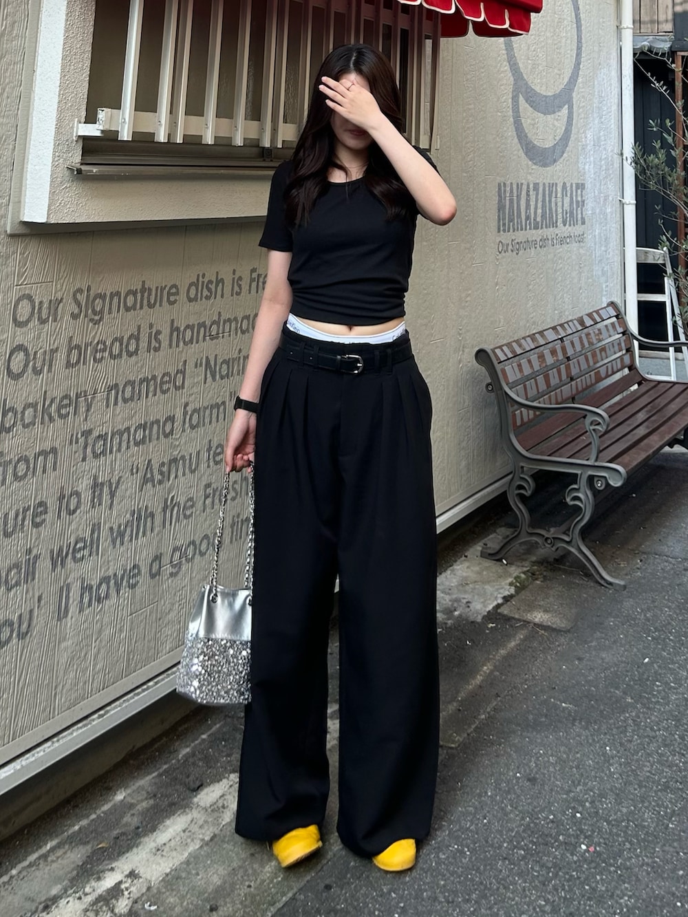 シルバー系のショルダーバッグ、ブラック系のTシャツ/カットソー、ブラック系のスラックスを着用したレディースの夏コーディネートの2枚目の写真