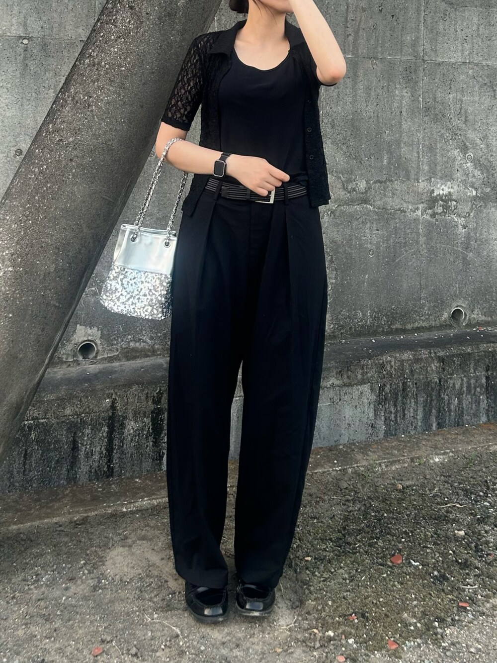 シルバー系のショルダーバッグ、ブラック系のポロシャツ、ブラック系のローファーを着用したレディースの夏コーディネートの4枚目の写真