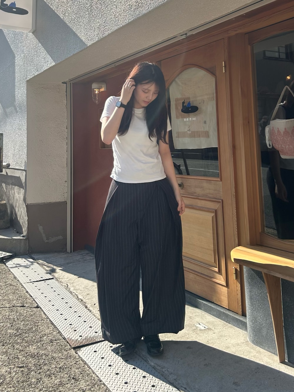 ホワイト系のTシャツ/カットソー、ブラック系のスラックス、ブラック系のローファーを着用したレディースの夏コーディネートの2枚目の写真