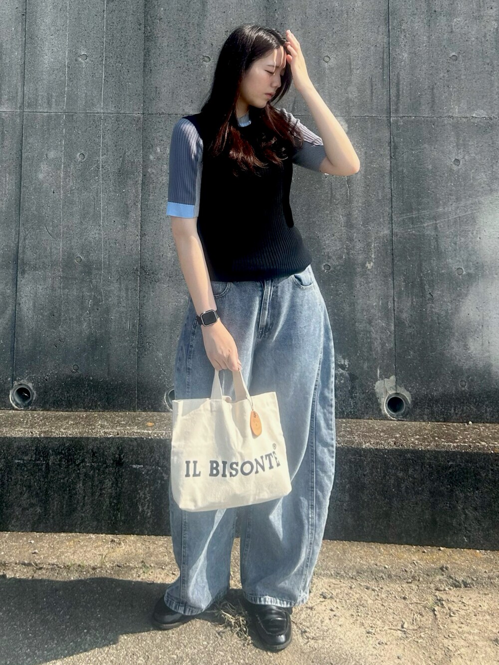 ブラック系のニット/セーター、ブラック系のローファー、ホワイト系のバッグを着用したレディースの夏コーディネートの3枚目の写真