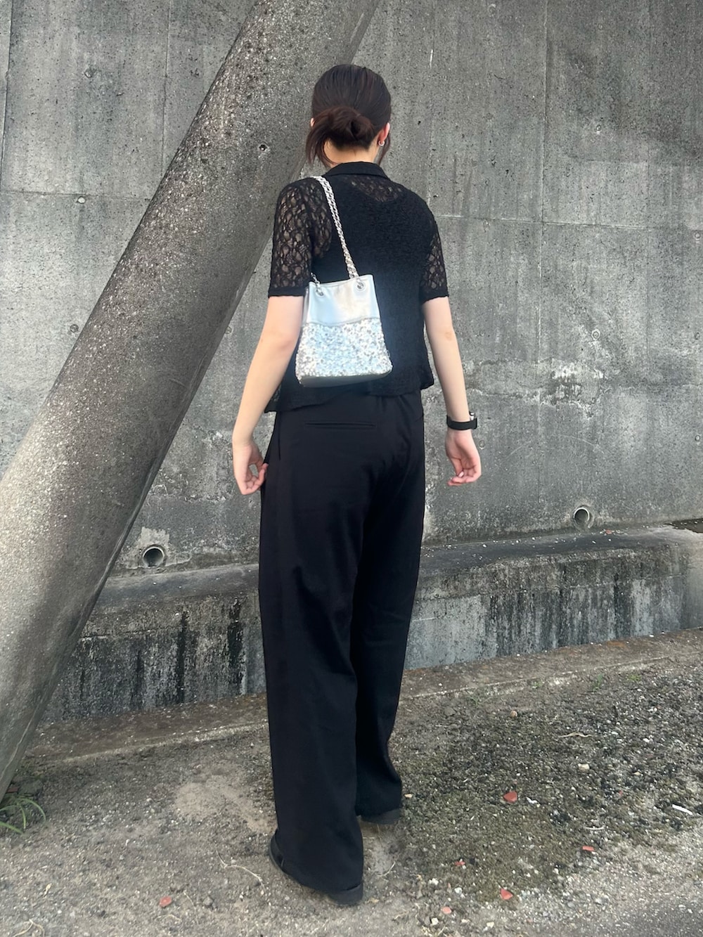 シルバー系のショルダーバッグ、ブラック系のポロシャツ、ブラック系のローファーを着用したレディースの夏コーディネートの3枚目の写真