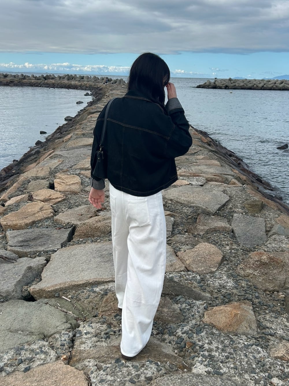 ブラウン系のスニーカー、ブラウン系のベルトを着用したレディースの秋コーディネートの2枚目の写真