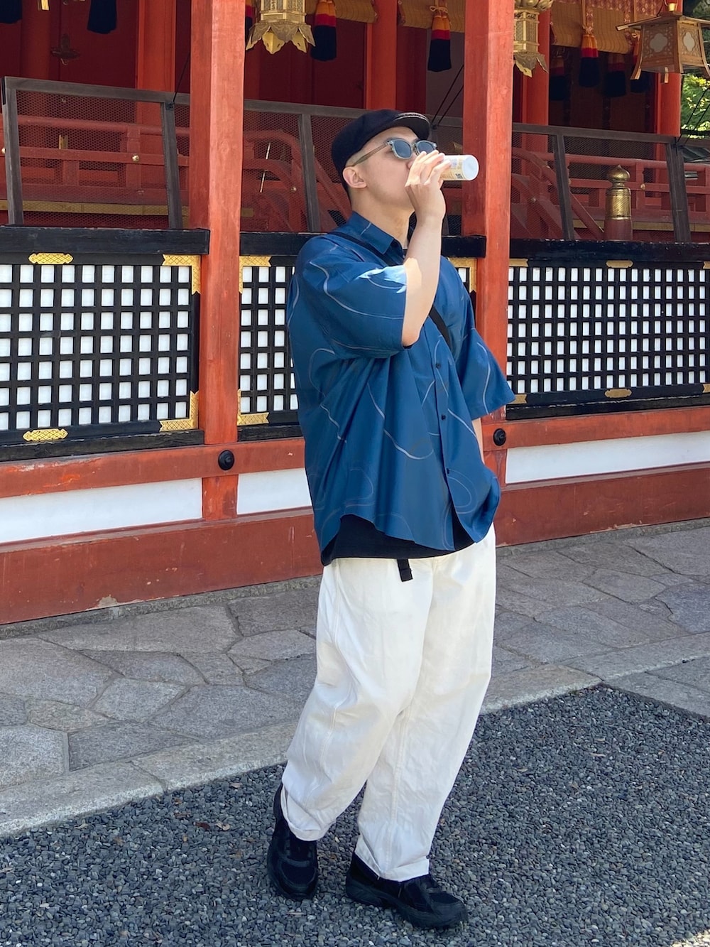 ホワイト系のチノパンツ、ブラック系のスニーカー、ブルー系のシャツ/ブラウスを着用したメンズの夏コーディネートの2枚目の写真