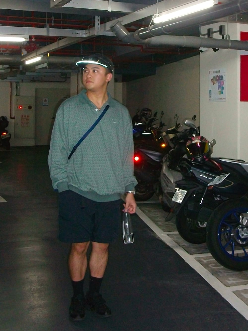 グリーン系のニット/セーター、ブラック系のカーゴパンツ、ブラック系のスニーカーを着用したメンズの秋コーディネートの2枚目の写真