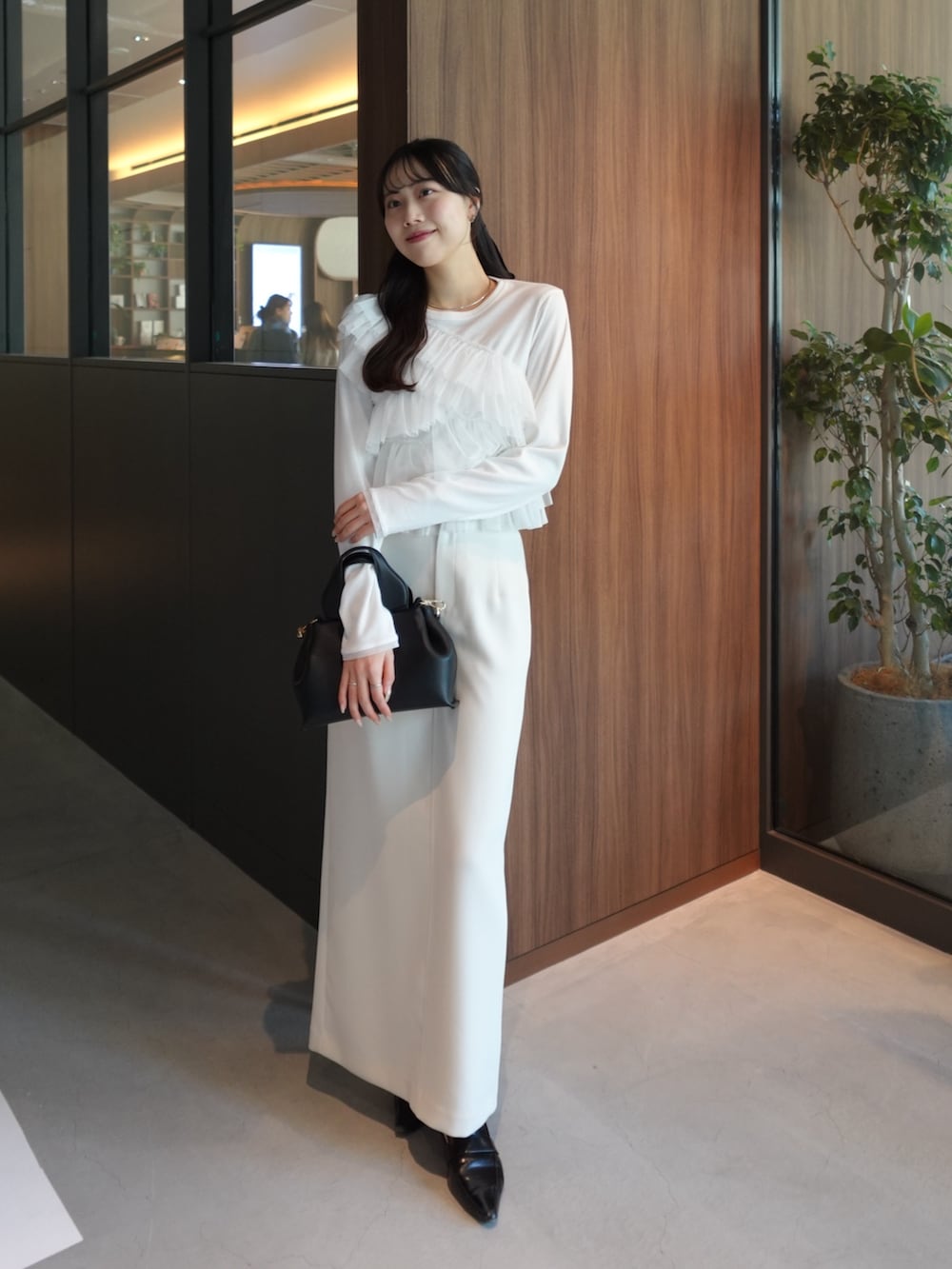 ベージュ系のテーラードジャケット、ホワイト系のTシャツ/カットソー、ホワイト系のスカートを着用したレディースの冬コーディネートの3枚目の写真