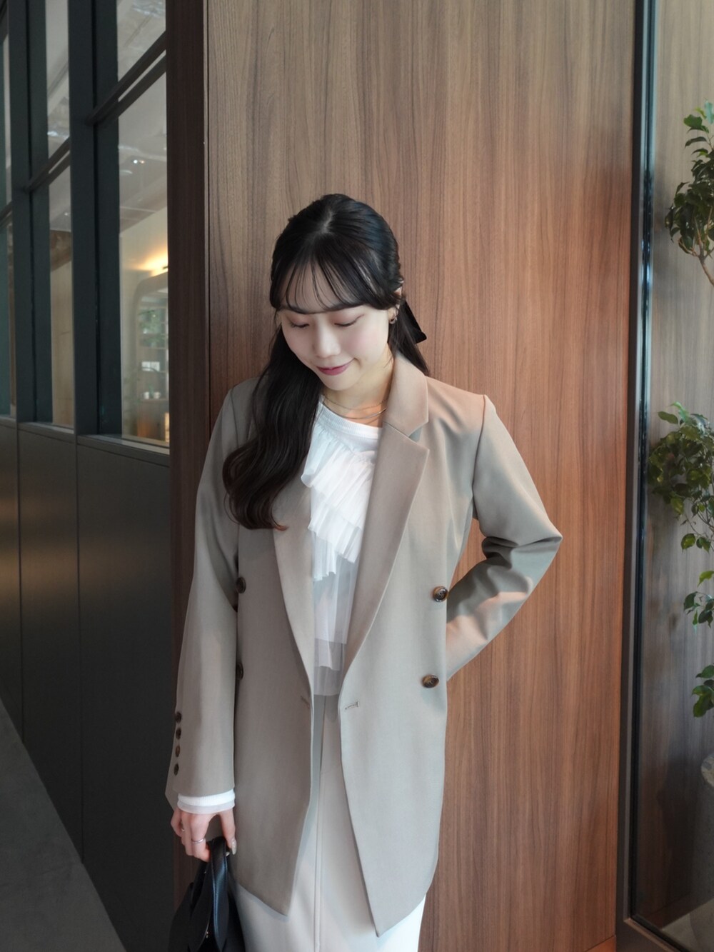 ベージュ系のテーラードジャケット、ホワイト系のTシャツ/カットソー、ホワイト系のスカートを着用したレディースの冬コーディネートの2枚目の写真