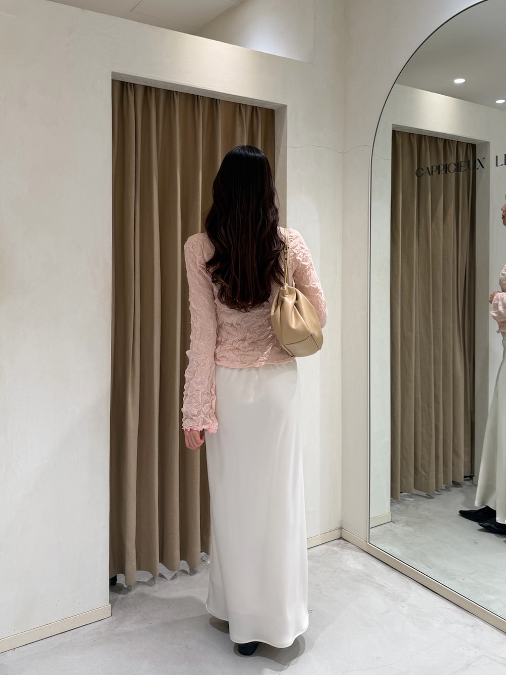 ブラック系のローファー、ベージュ系のショルダーバッグ、ピンク系のニット/セーターを着用したレディースの春コーディネートの3枚目の写真