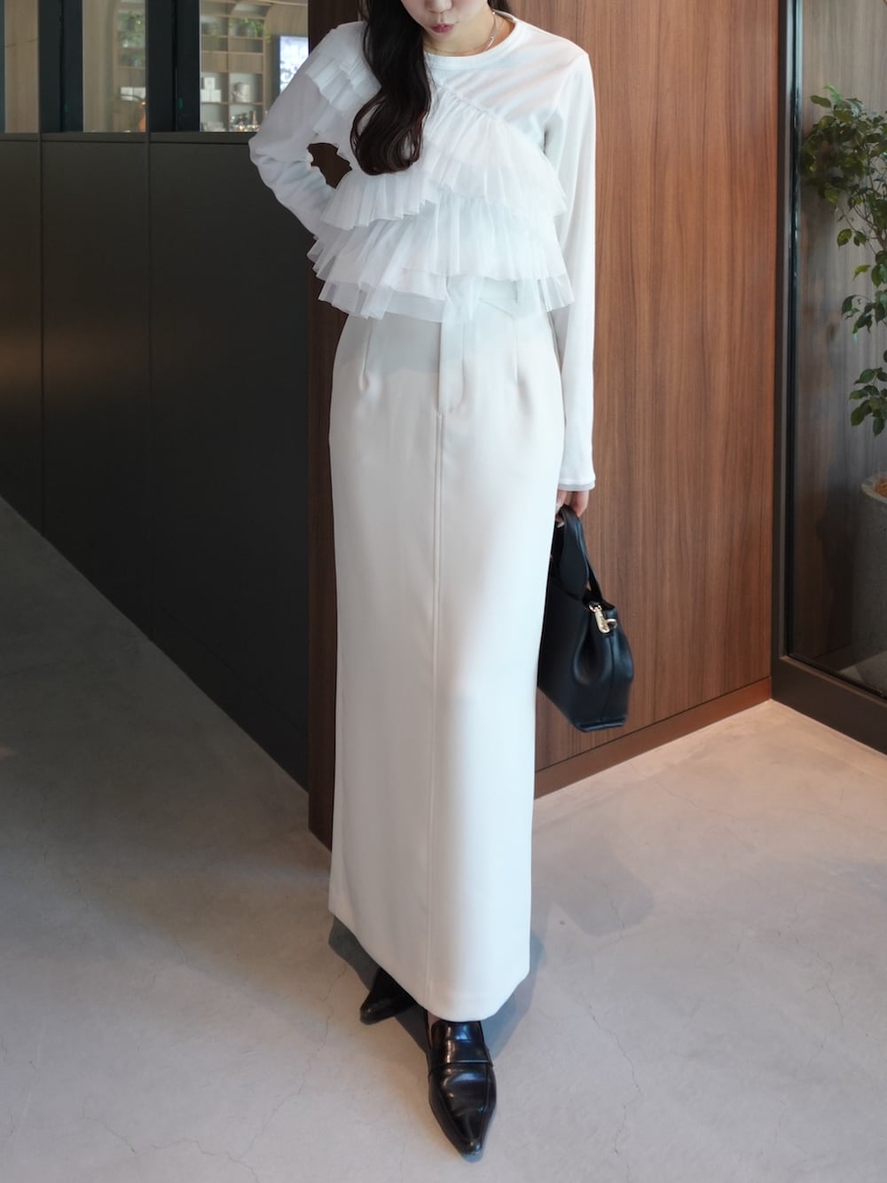 ベージュ系のテーラードジャケット、ホワイト系のTシャツ/カットソー、ホワイト系のスカートを着用したレディースの冬コーディネートの4枚目の写真