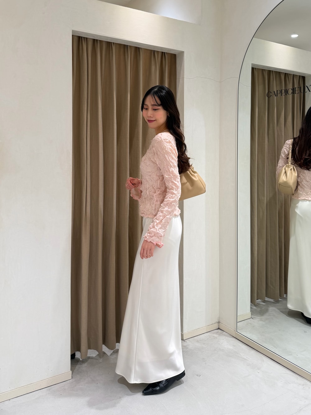 ブラック系のローファー、ベージュ系のショルダーバッグ、ピンク系のニット/セーターを着用したレディースの春コーディネートの2枚目の写真