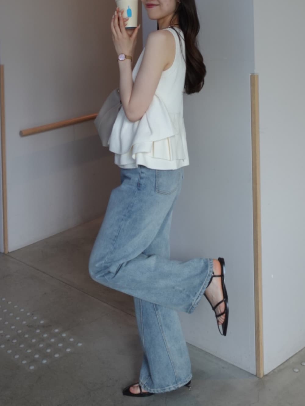 ホワイト系のニット/セーター、ブルー系のデニムパンツ、ホワイト系のショルダーバッグを着用したレディースの夏コーディネートの4枚目の写真