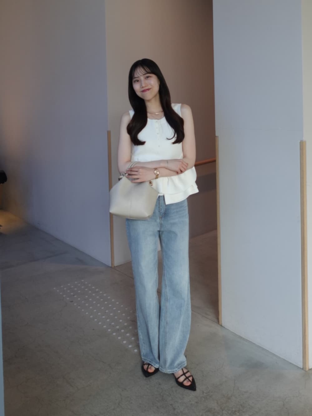 ホワイト系のニット/セーター、ブルー系のデニムパンツ、ホワイト系のショルダーバッグを着用したレディースの夏コーディネートの2枚目の写真