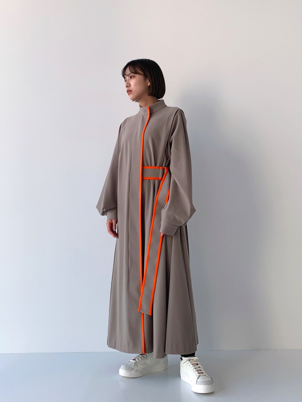 ベージュ系のワンピースを着用したレディースの秋コーディネートの2枚目の写真