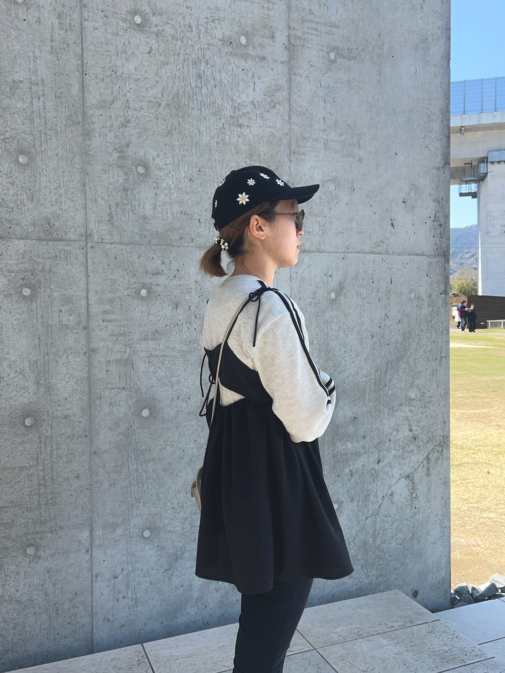 ブラック系のキャミソール、シルバー系のショルダーバッグ、グレー系のTシャツ/カットソーを着用したレディースの春コーディネートの2枚目の写真