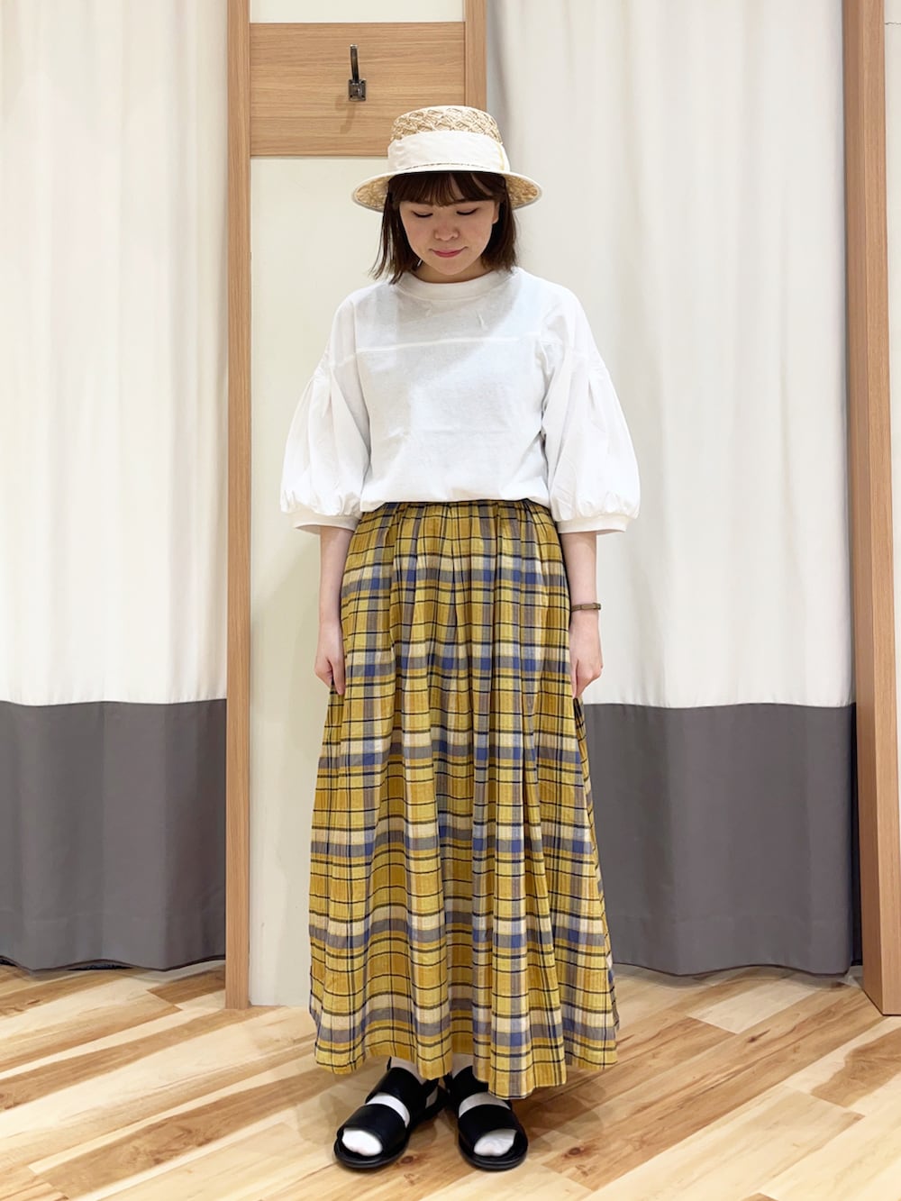 ホワイト系のTシャツ/カットソー、イエロー系のスカート、ホワイト系のハンドバッグを着用したレディースの春コーディネートの2枚目の写真