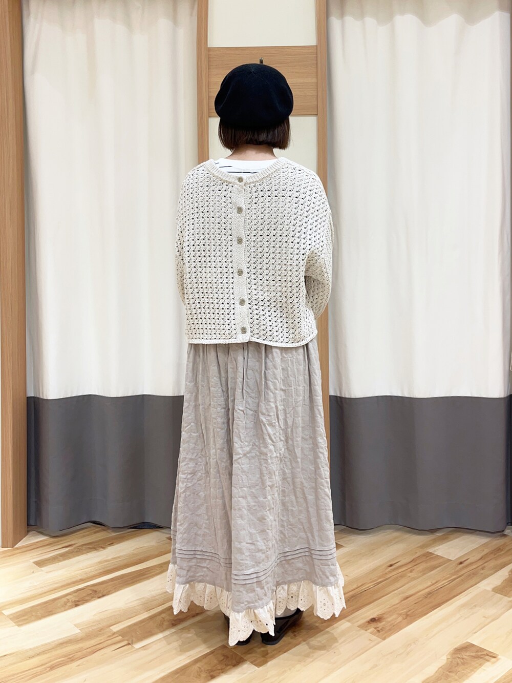 ベージュ系のカーディガン/ボレロ、ベージュ系のスカート、ブラック系のTシャツ/カットソーを着用したレディースの春コーディネートの2枚目の写真