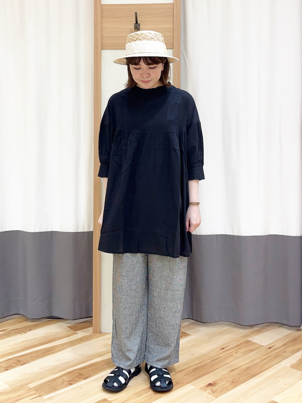 ブラック系のシャツ/ブラウス、グレー系のその他パンツ、ベージュ系のハンドバッグを着用したレディースの春コーディネートの2枚目の写真