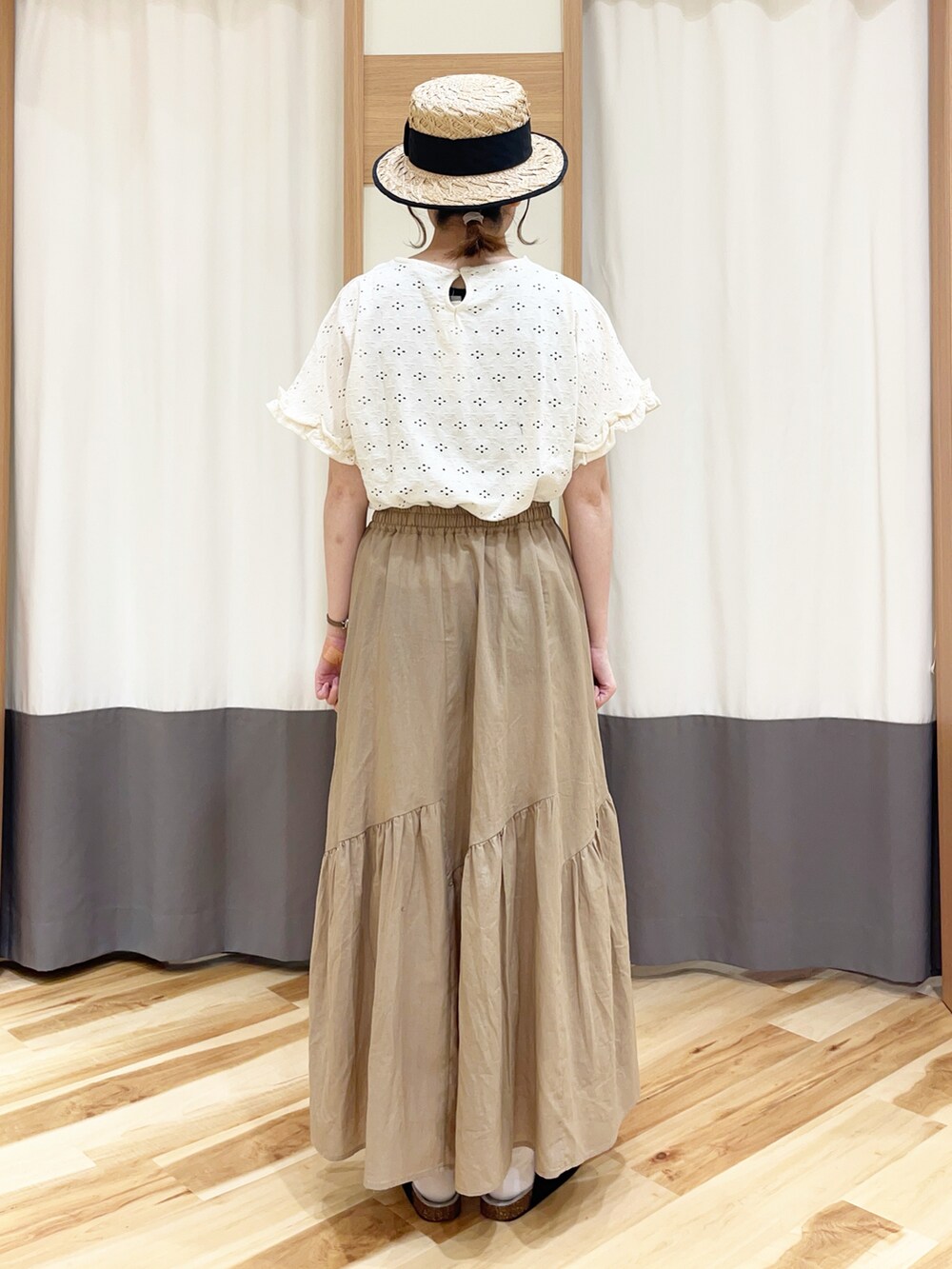 ホワイト系のTシャツ/カットソー、ベージュ系のスカート、ブラック系のハットを着用したレディースの夏コーディネートの3枚目の写真